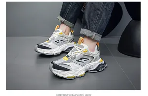 Detailed side view of men's chunky sneakers in grey and yellow with platform soles.