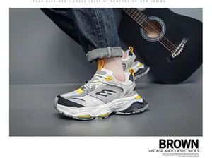Detailed side view of stylish chunky platform dad sneakers for men in gray and yellow.