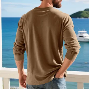 Vue arrière d'un homme portant un sweat-shirt en velours côtelé marron au bord de l'eau.
