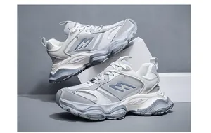 Detailed side view of chunky platform dad sneakers in stylish white and grey tones