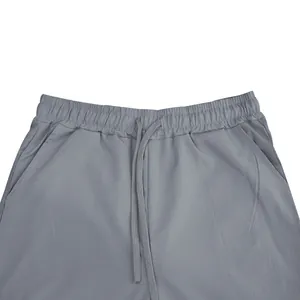 Detailopname van grijze vrijetijdsbroek voor heren met elastische taille en koord.