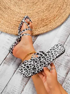 Close-up of stylish leopard print square toe flat sandals with crisscross straps for women.