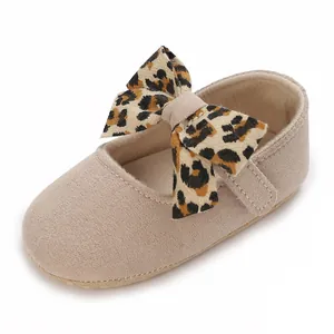 Close-up of beige baby girl walking shoe with a leopard print bow detail.