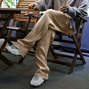 Detalle de pantalones plisados caqui para hombre, de pierna ancha con rayas texturizadas