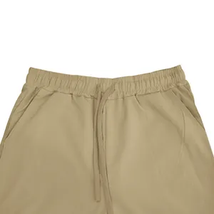 Close-up detail van de elastische tailleband met trekkoord van een khaki herenbroek.