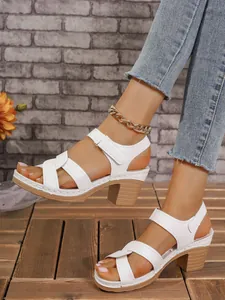 Sandalias blancas de tacón alto con correas cruzadas y cierre de velcro para el verano.
