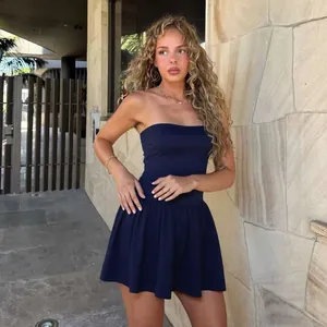 Model wearing a navy blue strapless pleated mini dress in an outdoor street setting