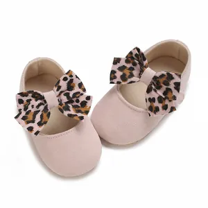 Close-up of pink baby girl walking shoes with stylish leopard print bows