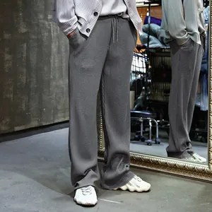 Detalle de pantalones anchos grises para hombre con textura de canalé y cordón