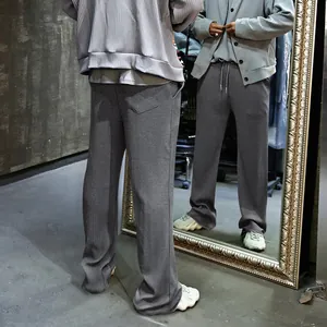 Pantalones anchos de hombre en gris con cordón y textura de canalé, estilo informal.