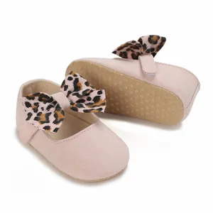 Detailed close-up of pink baby girl shoes featuring leopard bow and non-slip dotted sole