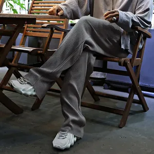 Vista de detalle de pantalones plisados grises de hombre con textura de canalé