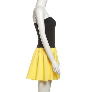 Side view of a chic black and yellow color-blocked strapless pleated mini dress