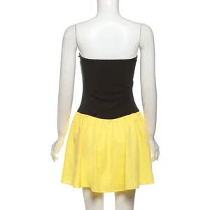 Back view of a color block strapless dress with black top and yellow pleated skirt