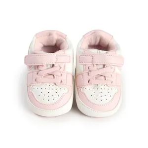 Top-down view of pink and white soft-soled baby walking shoes with durable velcro strap