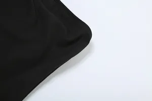 Detail close-up of high-quality black fabric texture and stitching on a pleated dress