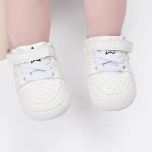 Detailed view of white baby walking shoes with a velcro strap and elastic laces
