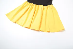 Close-up detail of a fashion color block pleated dress in black and vibrant yellow