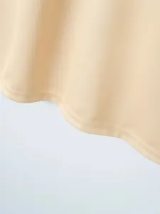 Nahaufnahme der feinen Textur und des doppelt genähten Saums eines beigen Herren-Poloshirts.