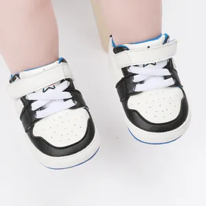 Detailed view of black and white baby walking shoes with secure strap and soft sole