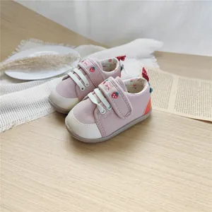 Detailed view of pink baby walking shoes featuring cute strawberry embroidery and soft sole