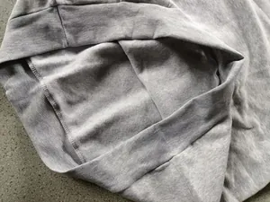 Detailed view of grey fleece lining and ribbed hem on a men's sports hoodie