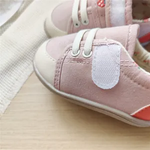 Detailed view of pink baby walking shoes featuring strawberry embroidery and velcro closure