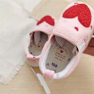 Detailed view of the soft cushioned insole and lining of these pink baby walking shoes.