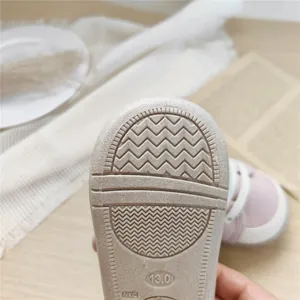 Macro detail of the anti-slip textured rubber sole on soft-soled baby walking shoes