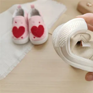 Detail of soft and flexible sole on pink baby canvas shoes with heart design