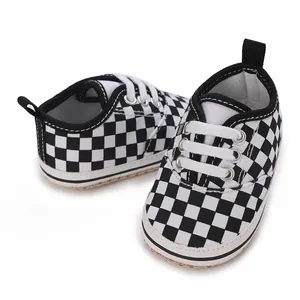Detailed view of baby boy soft sole shoes with black and white checkerboard pattern