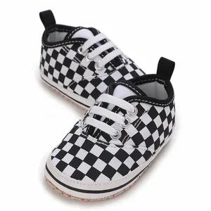 Close-up detail of checkered infant walking shoes with soft soles and white laces