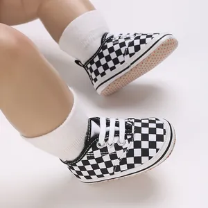 Detail of black and white checkerboard canvas baby shoes with soft non-slip soles.