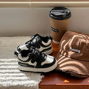 Primer plano de cómodos zapatos de marcha blancos y negros para niños en un alféizar soleado
