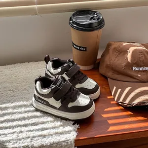 Vista detallada de zapatillas casuales marrones y blancas para niños con velcro