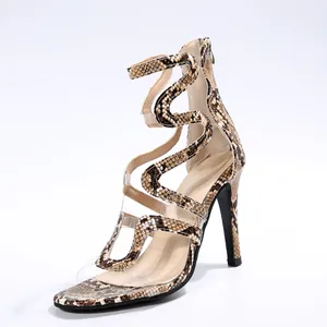 Detailed view of women's snakeskin stiletto sandals with transparent PVC crisscross straps.