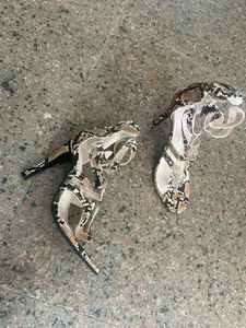 Detailed view of women's snakeskin pattern high heel sandals with cross straps.