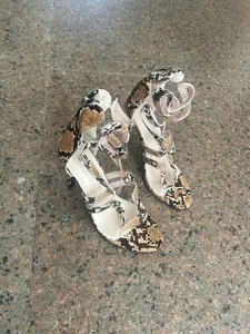 A high-angle detailed view of snakeskin pattern strappy high heel sandals for women.