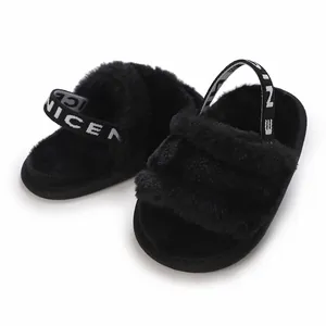Gros plan de chaussons pour bébé en fausse fourrure noire avec bride arrière élastique 'NICE'