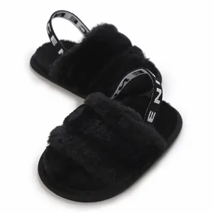 Vue détaillée de sandales en fausse fourrure noire pour bébé avec bride arrière élastique
