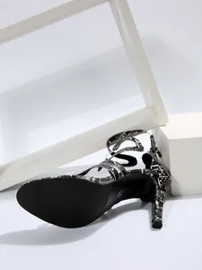 Detailed view of snake print high heel sandals with stylish cross straps