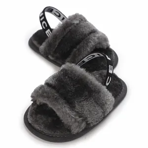 Vue rapprochée de sandales en fourrure grise pour bébé fille avec sangle élastique.