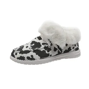 Gros plan sur la doublure en fausse fourrure blanche et le motif vache de ces bottines.