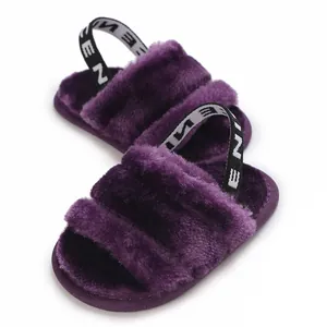 Vue détaillée de sandales pour bébé en fausse fourrure violette avec bride arrière élastique.