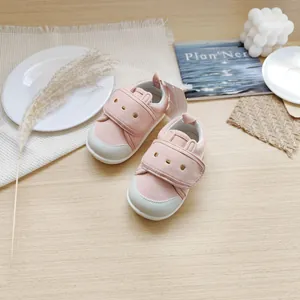 Vue détaillée des chaussures de marche pour bébé rose avec motif lapin et semelle souple