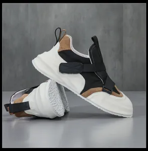 Zijaanzicht van heren lederen sneakers met zwart-wit patchwork en klittenbandsluitingen.