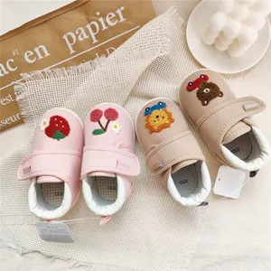 Detail of soft-soled baby walking shoes featuring cute strawberry and bear embroidery.