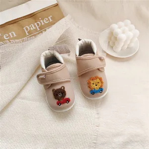 Detailed view of soft-sole baby walking shoes with cute bear and lion embroidery.