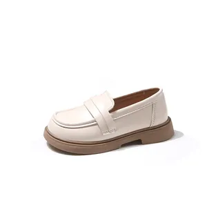 Detailaufnahme von eleganten cremefarbenen Kinderslippern mit weicher Gummisohle