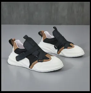 Zijaanzicht van modieuze leren herensneakers met gekruiste klittenbandsluiting
